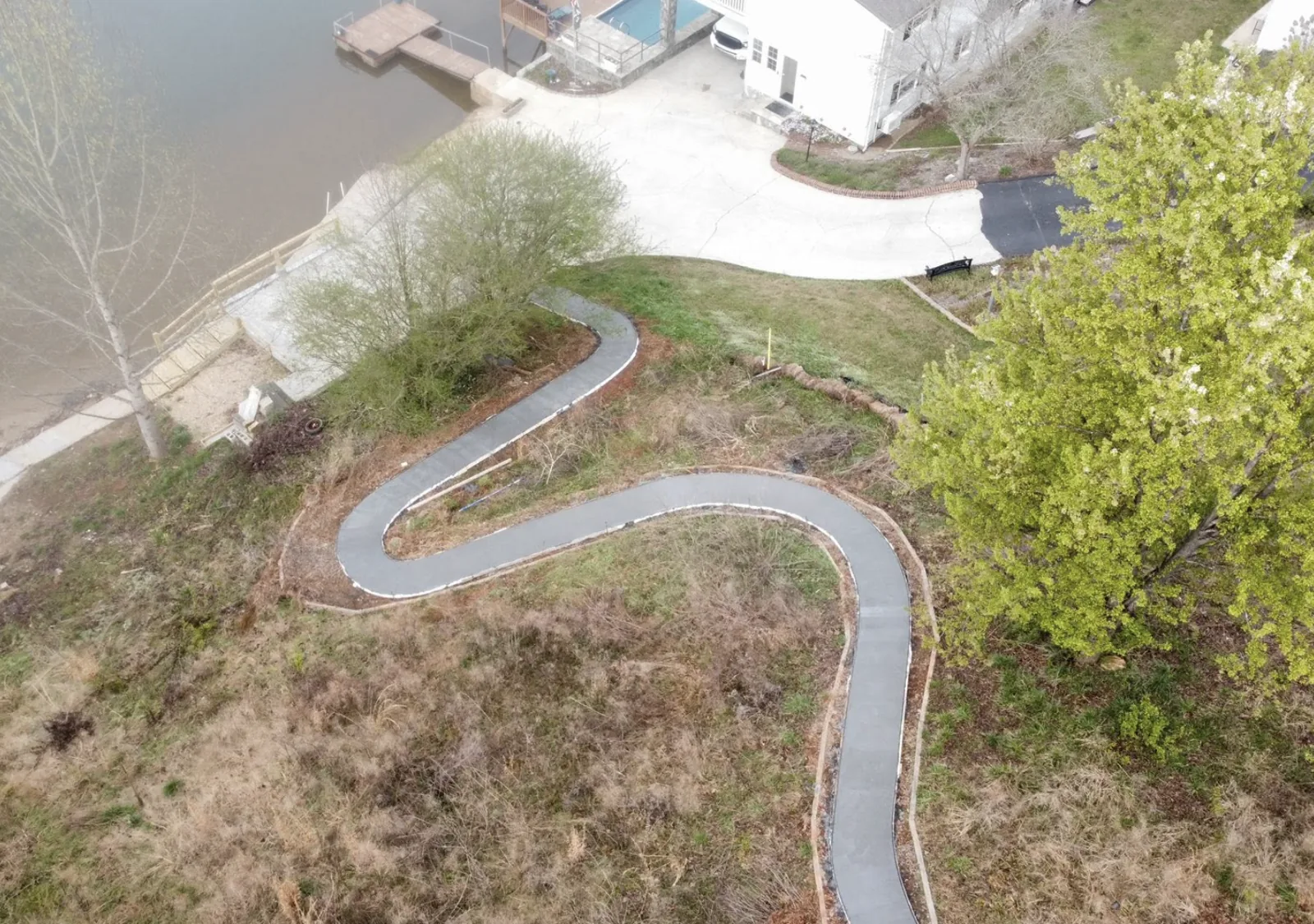 Aerial view of a winding concrete path installed on a lakeside property near Lake Norman, NC