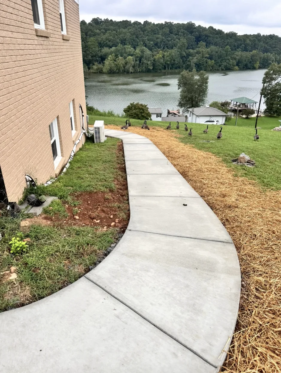 New concrete walkway running alongside a two-story home