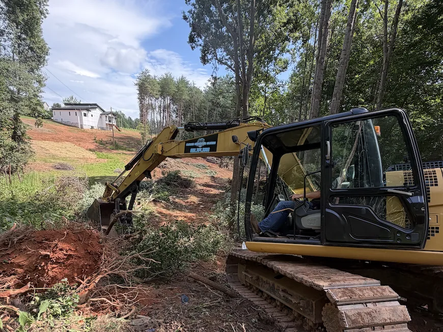 Platinum Construction & Crane excavator removing brush and undergrowth from a residential lot near Hickory, NC
